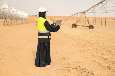 مهندسة عربية تستخدم جهاز لوحي في مزرعة صحراوية