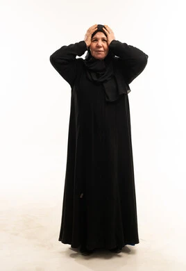 امرأة عربية مسنة بالعباءة تعاني من الصداع