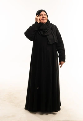 امرأة سعودية مسنة بالعباءة السوداء في وضعية تفكير