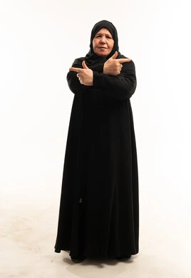 امرأة سعودية مسنة تشير في اتجاهات متعاكسة