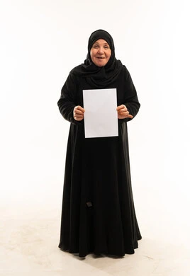 امرأة سعودية مسنة تحمل ورقة بيضاء فارغة