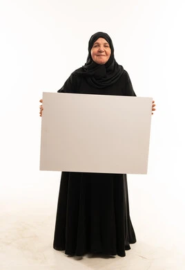 امرأة عربية مسنة تحمل لوحة بيضاء فارغة