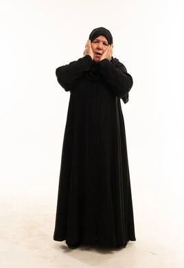 امرأة سعودية مسنة بالعباءة بتعبيرات وجه مندهشة