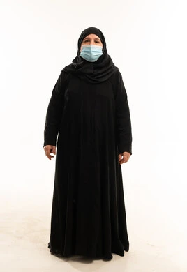 امرأة سعودية بالعباءة السوداء والكمامة الطبية