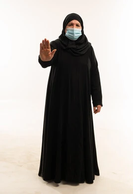 Senior Arab Woman in Abaya with Mask Stop Gesture