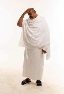 رجل سعودي بملابس الإحرام يشعر بالتعب والإرهاق