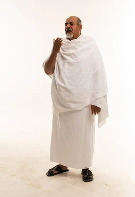 رجل سعودي بملابس الإحرام يشعر بالتعب والإرهاق