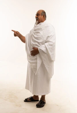 رجل سعودي بملابس الإحرام يشير للأمام