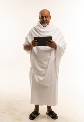 حاج سعودي بملابس الإحرام يستخدم جهاز لوحي