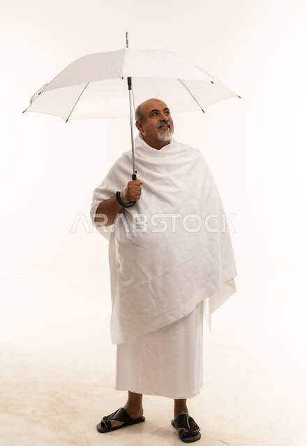 Saudi Pilgrim in Ihram Holding Umbrella on White Background