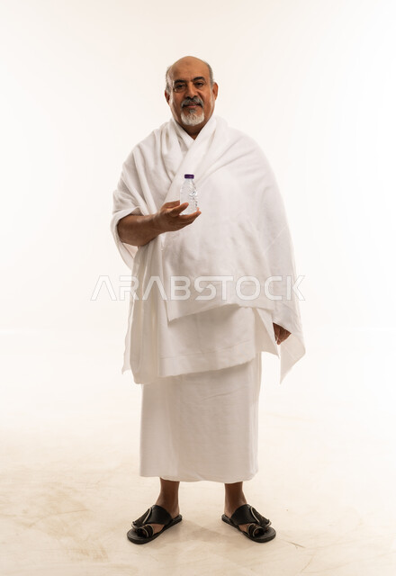 Saudi Senior Man in Ihram Clothing Holding Water Bottle