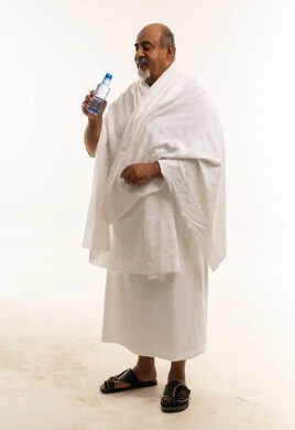 رجل سعودي بملابس الإحرام يحمل زجاجة ماء