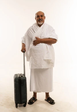 حاج عربي بملابس الإحرام مع حقيبة سفر خلفية بيضاء