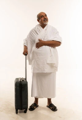رجل سعودي بملابس الإحرام مع حقيبة سفر