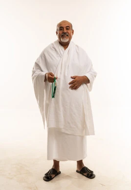 رجل سعودي مسن بملابس الإحرام يمسك مسبحة