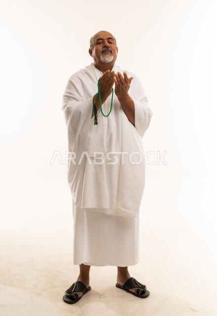 Elderly Saudi Man in Ihram Praying with Beads