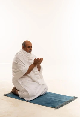 رجل سعودي مسن بملابس الإحرام يدعو الله