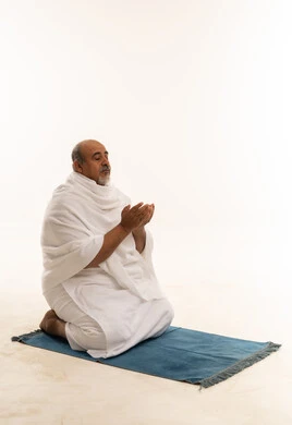 Saudi Man in Ihram Praying on Blue Mat