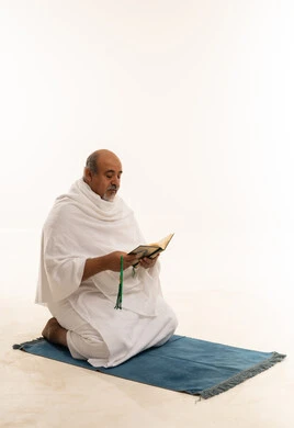 حاج سعودي بملابس الإحرام يقرأ القرآن الكريم