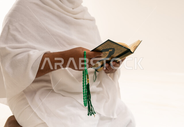 رجل سعودي بملابس الإحرام يقرأ القرآن الكريم