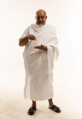 رجل سعودي بملابس الإحرام البيضاء بخلفية بيضاء