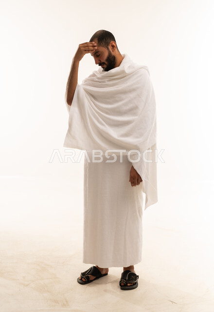 رجل مسلم بملابس الإحرام البيضاء بخلفية بيضاء