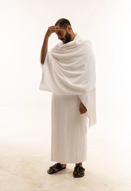 رجل مسلم بملابس الإحرام البيضاء بخلفية بيضاء