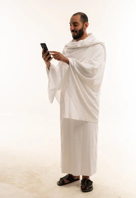 Saudi Man in Ihram Using Smartphone on White Background