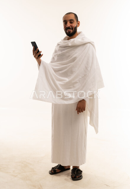 Saudi Man in Ihram Using Smartphone on White Background