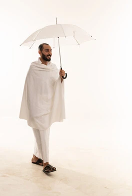 Saudi Man in Ihram Clothing Walking with Umbrella