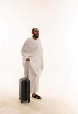 رجل سعودي بملابس الإحرام مع حقيبة سفر