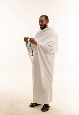 رجل سعودي بملابس الإحرام يمسك مسبحة خلفية بيضاء