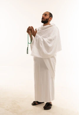 رجل سعودي بملابس الإحرام يدعو بالمسبحة