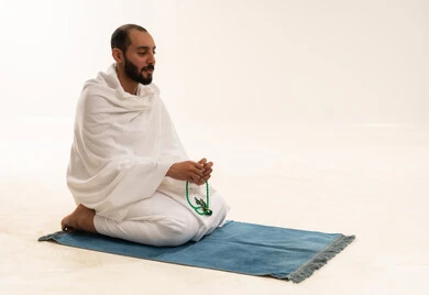 Saudi Pilgrim in Ihram with Prayer Beads on White Background