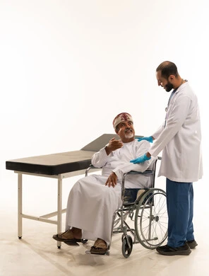 مريض عماني على كرسي متحرك يستشير طبيب مختص