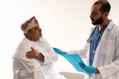 Omani Doctor Consults Elderly Patient in Clinic