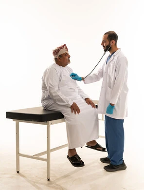 طبيب يفحص مريض عماني مسن في عيادة طبية