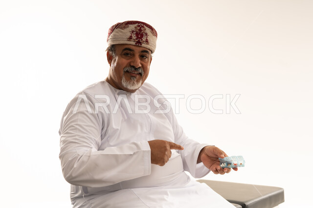 رجل عُماني بالزي التقليدي يحمل قالب أسنان