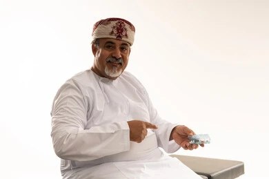 رجل عُماني بالزي التقليدي يحمل قالب أسنان