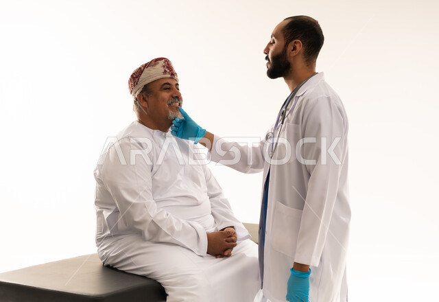 طبيب أسنان عماني يفحص مريض مسن بالزي التقليدي
