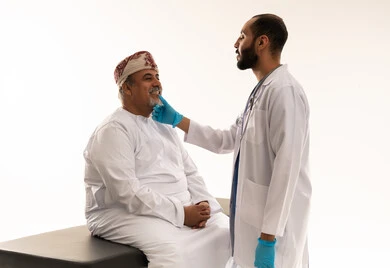 طبيب أسنان عماني يفحص مريض مسن بالزي التقليدي