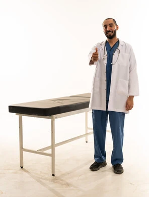 طبيب سعودي يبتسم ويشير بعلامة الإعجاب في العيادة