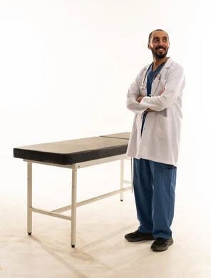 طبيب سعودي يرتدي السكراب يقف بجوار سرير الفحص