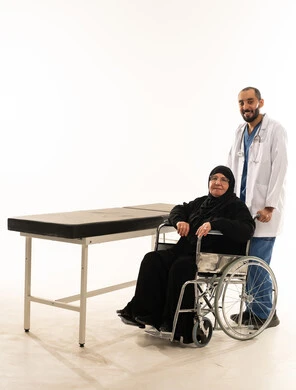 طبيب سعودي مع مريضة مسنة على كرسي متحرك