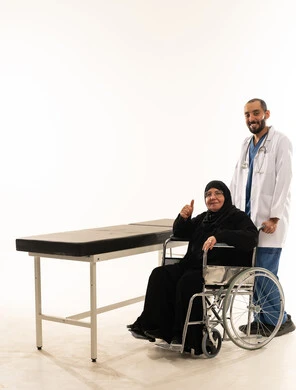 طبيب سعودي مع مريضة مسنة على كرسي متحرك