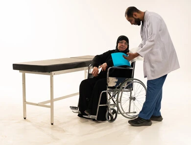 طبيب سعودي يستشير مريضة مسنة على كرسي متحرك