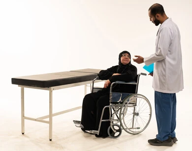 طبيب سعودي يستشير مريضة مسنة على كرسي متحرك