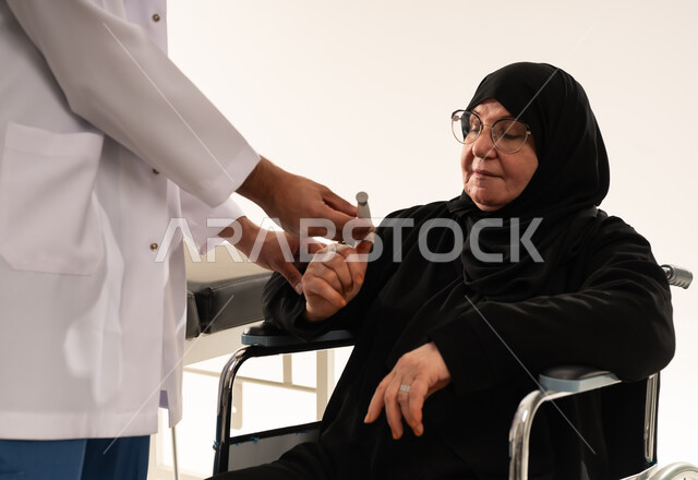 طبيب سعودي يفحص مستوى السكر لمريضة مسنة