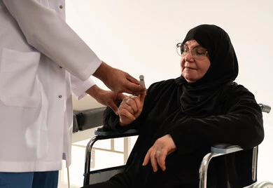طبيب سعودي يفحص مستوى السكر لمريضة مسنة