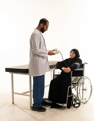طبيب عربي يقيس ضغط دم مريضة مسنة